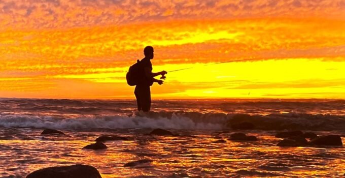 sunset fisherman and fishing backpack silhouette