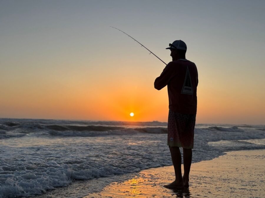 Angler surf fishing at sunset on a Southern California beach